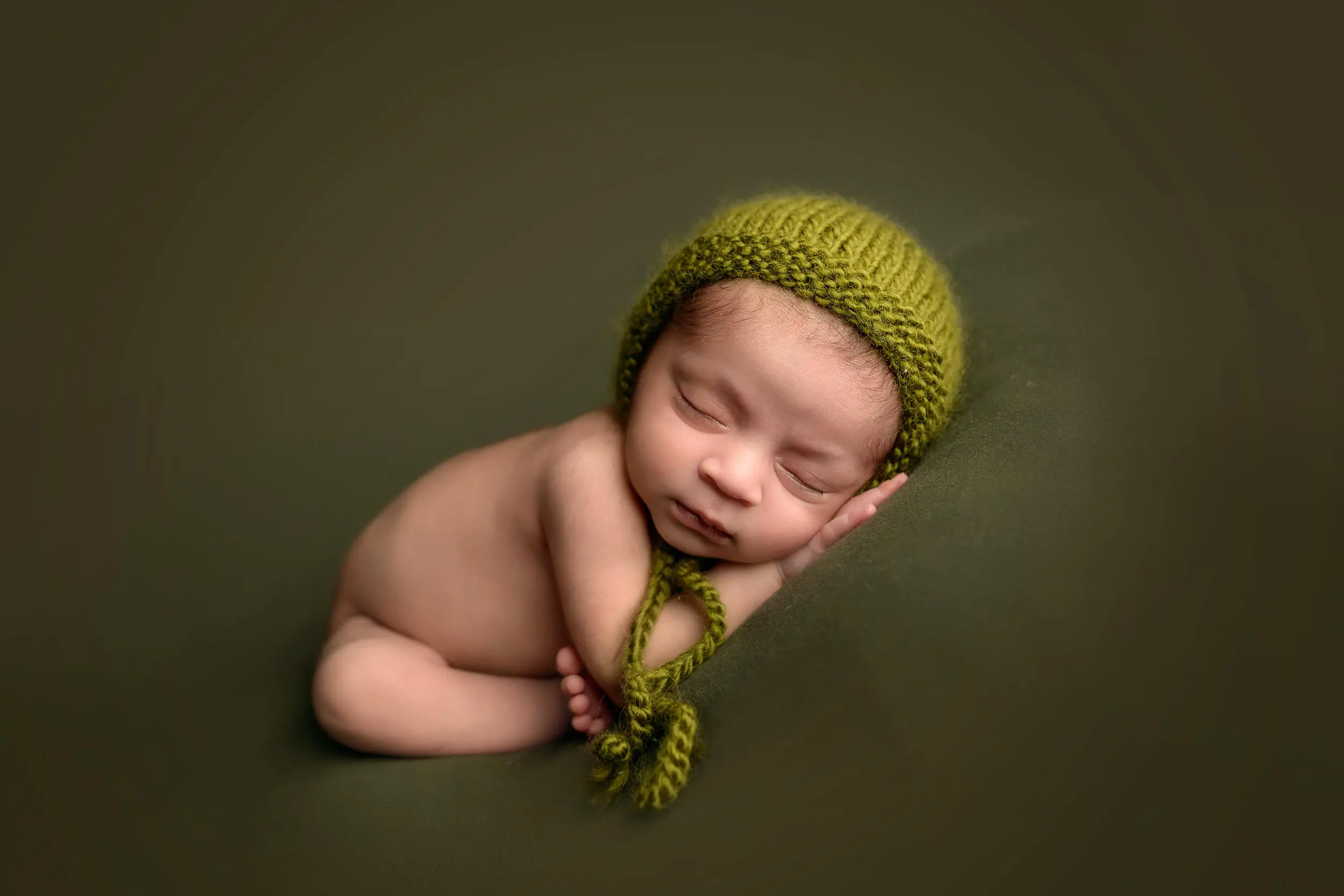 Adorable newborn baby on green background.