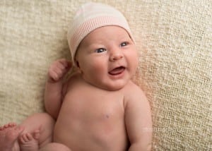 A photo of a sweet newborn girl smiling.