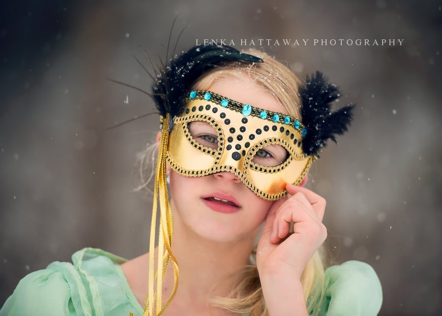 A close-up of a girl with a mask. Snow is falling.