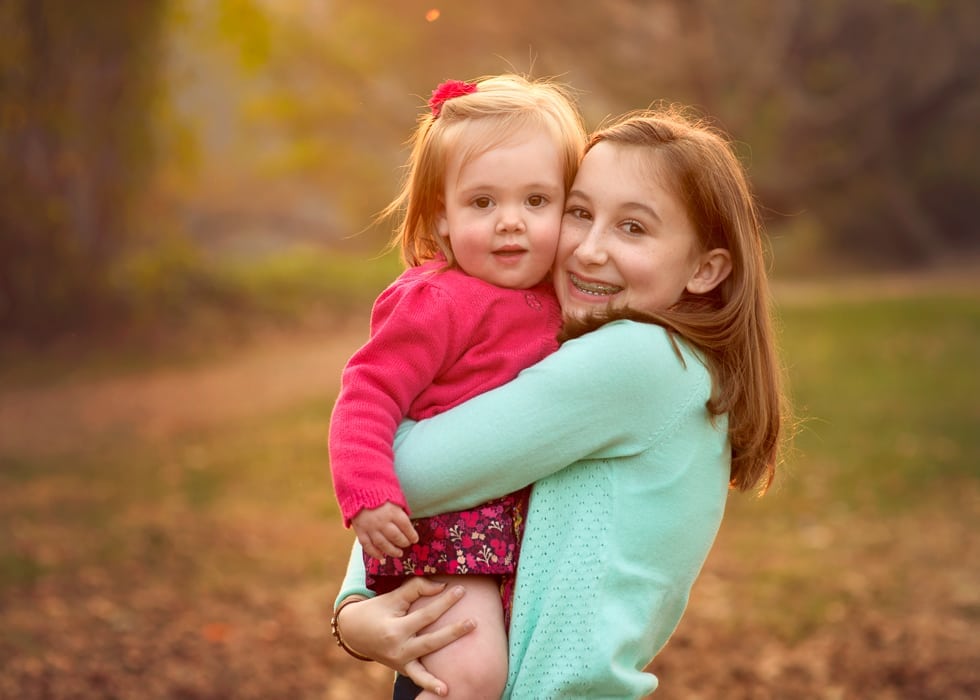 A colorful photo of a girl being held by her cousin. Photo taken at Amboy park in Asheville.