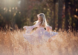 A photo of a girl dancing in sunshine.