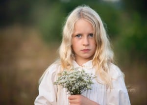A photo of a child holding flowers in her hands.
