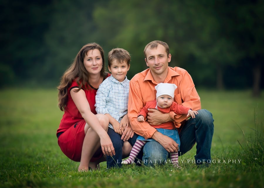 A beutiful professional photo of a young family. Parents with two children, a boy and a girl crouching down.