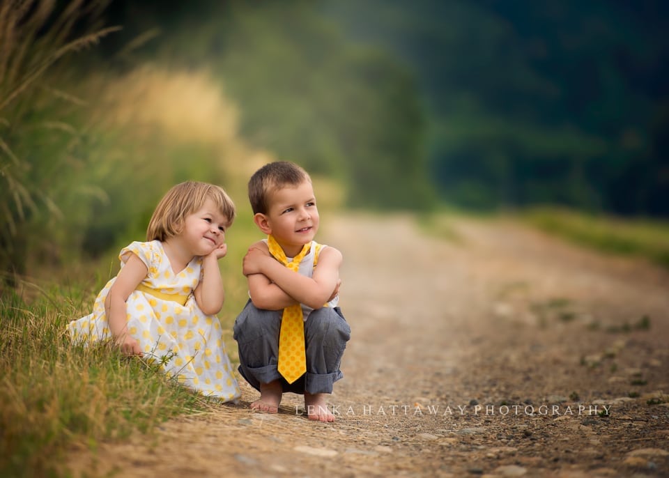 A photo of two lottle children (a girl and a boy) crouching down.