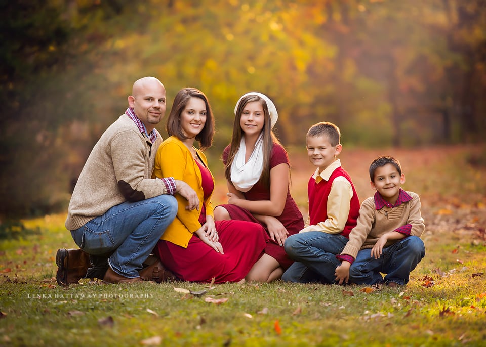 A lovely image of a family with fall colors in the background.