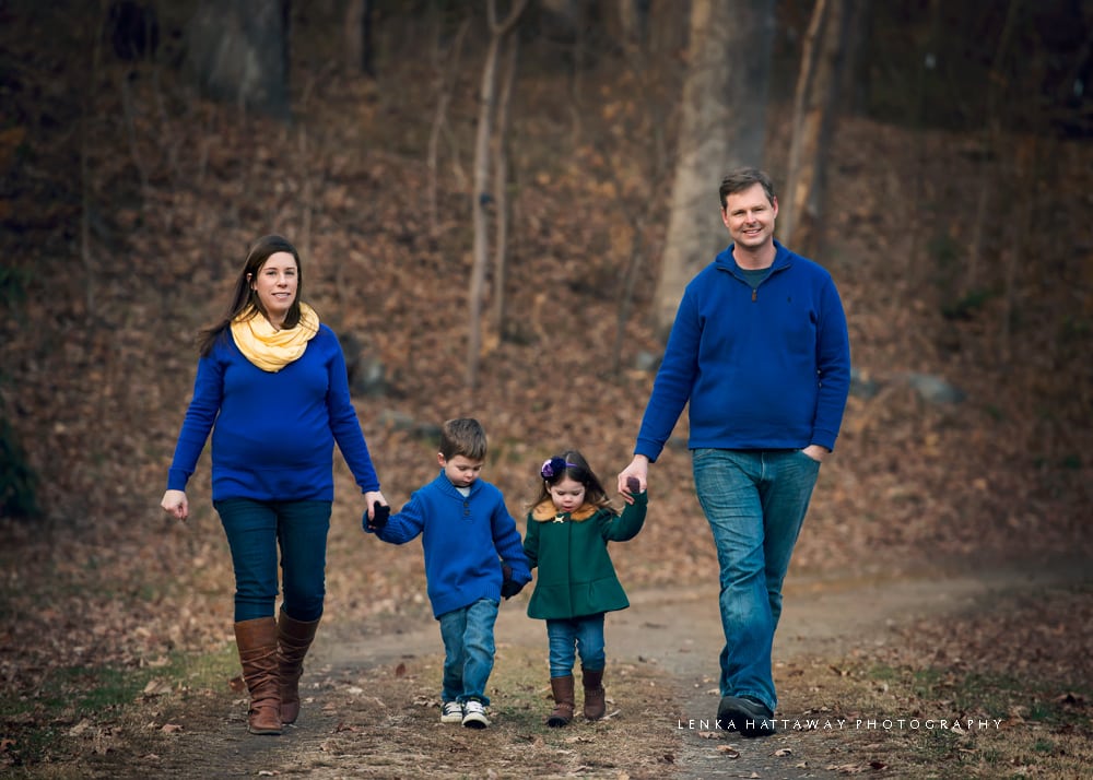 Winter maternity photo of a family walking holding hands.