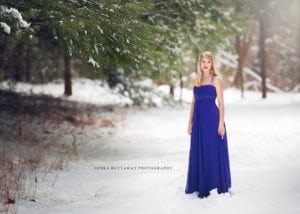 A beautiful shot of a teen girl in a purple dress against white snow.