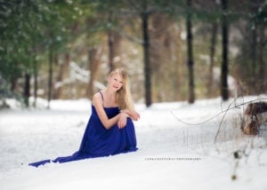 A beautiful image of a teen in a purple dress against white snow.