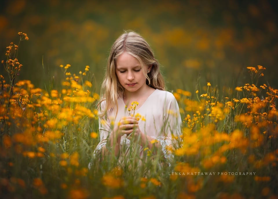 A child in a field of beautiful yellow flowers.