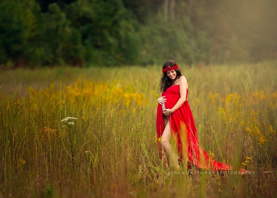 A lovely image of an expecting mama dressed in a red long dress.
