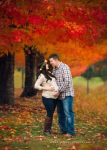 A fall image of a couple expecting a baby.