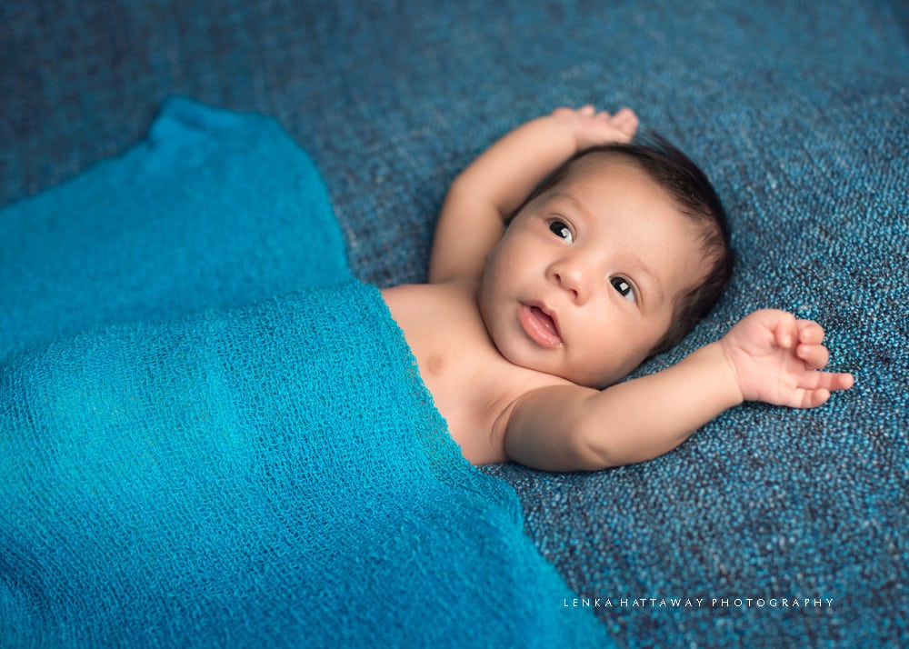 Photo of a baby with a blue blanket.