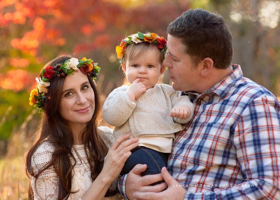 A photo from the Asheville Arboretum of a family of three. Fall background.