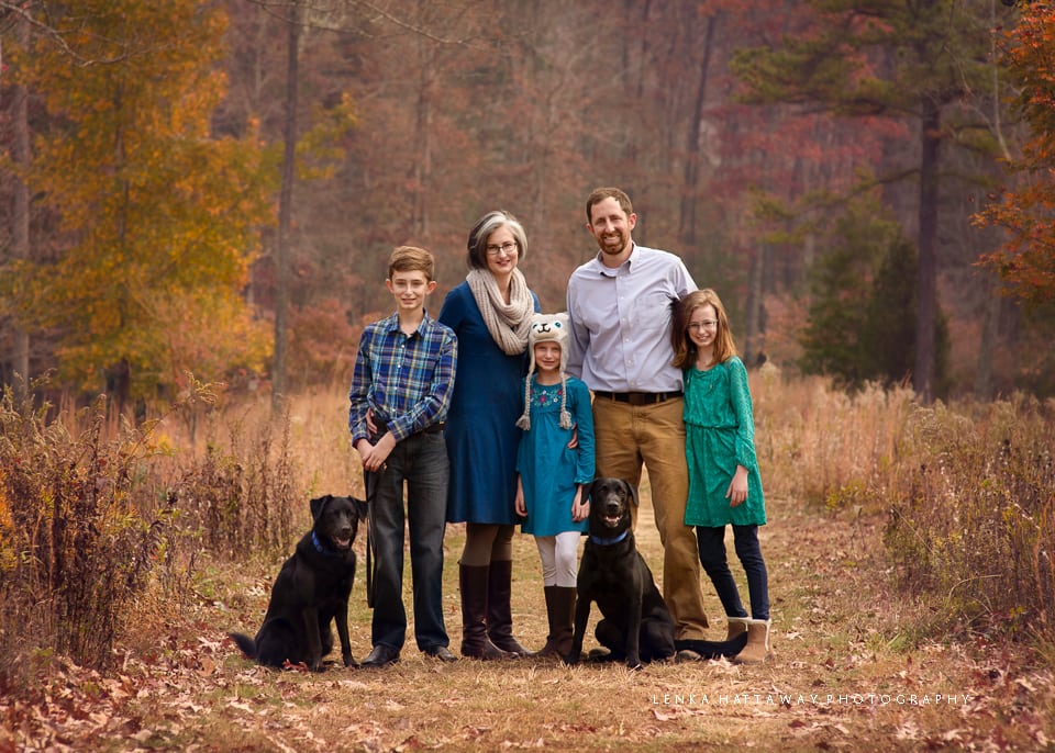A family of five photographed at the Asheville Arboretum with their two dogs.