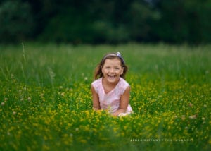 Smiling child portrait in grass.
