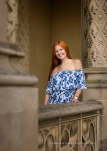 A lovely young woman standing by railing of the Biltmore House.