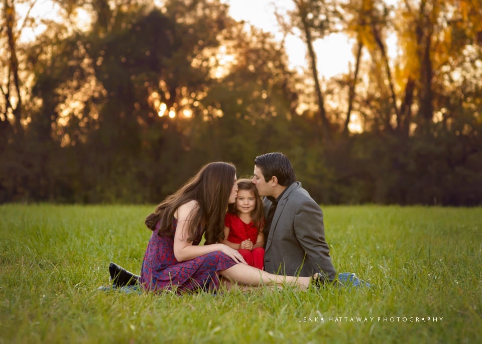 Mother and father both kissing their daughter during their photo session in Asheville, NC.