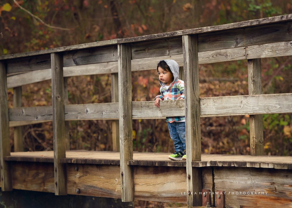 A photo of a child standing on a bridge.