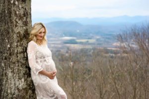 Maternity photo of an expecting mom leaning against a tree.