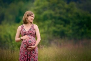 Pregnancy portrait in a green setting.