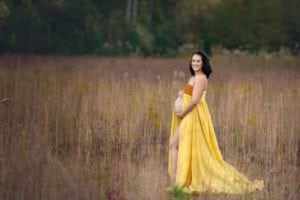 Pregnancy portrait of mom in a long yellow gown.