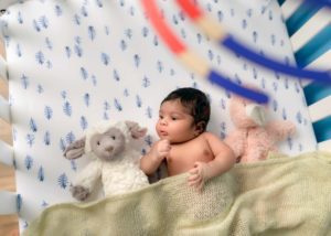 Newborn in a crib during a newborn photo session in Asheville, NC,