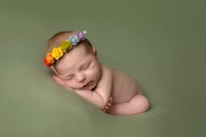 Newborn photo of a baby girl with a flower headband.