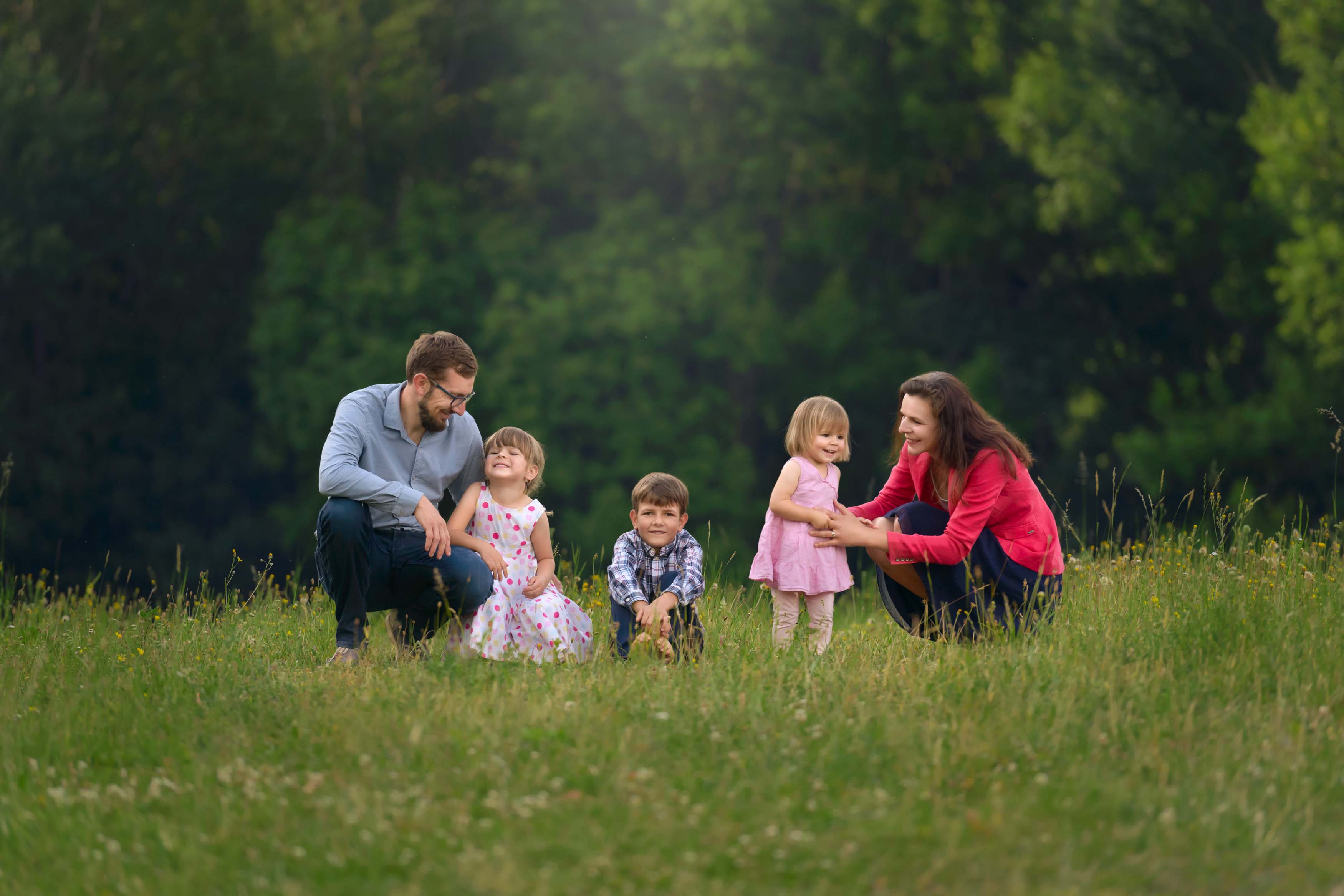 Photo of a family with four small children in a meadow.