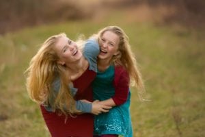 Fun photo of two girls, sisters, laughing.