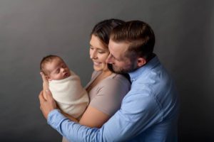 Newborn baby being held by his parents.