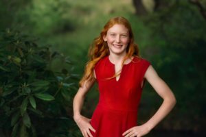 Stunning portrait of a red-hair girl in a red dress.