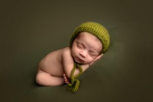 Adorable newborn baby on green background.