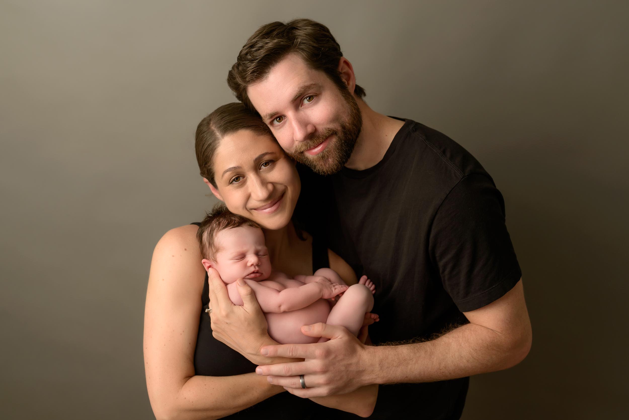Newborn photography of mom, dad and their baby.