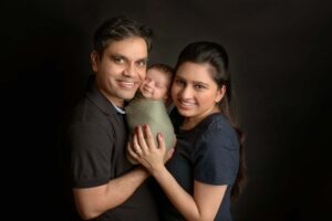 Parents holding their smiling newborn baby.