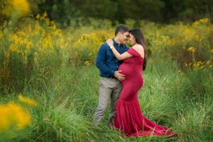 Asheville maternity photo of a couple in golden rod flowers.