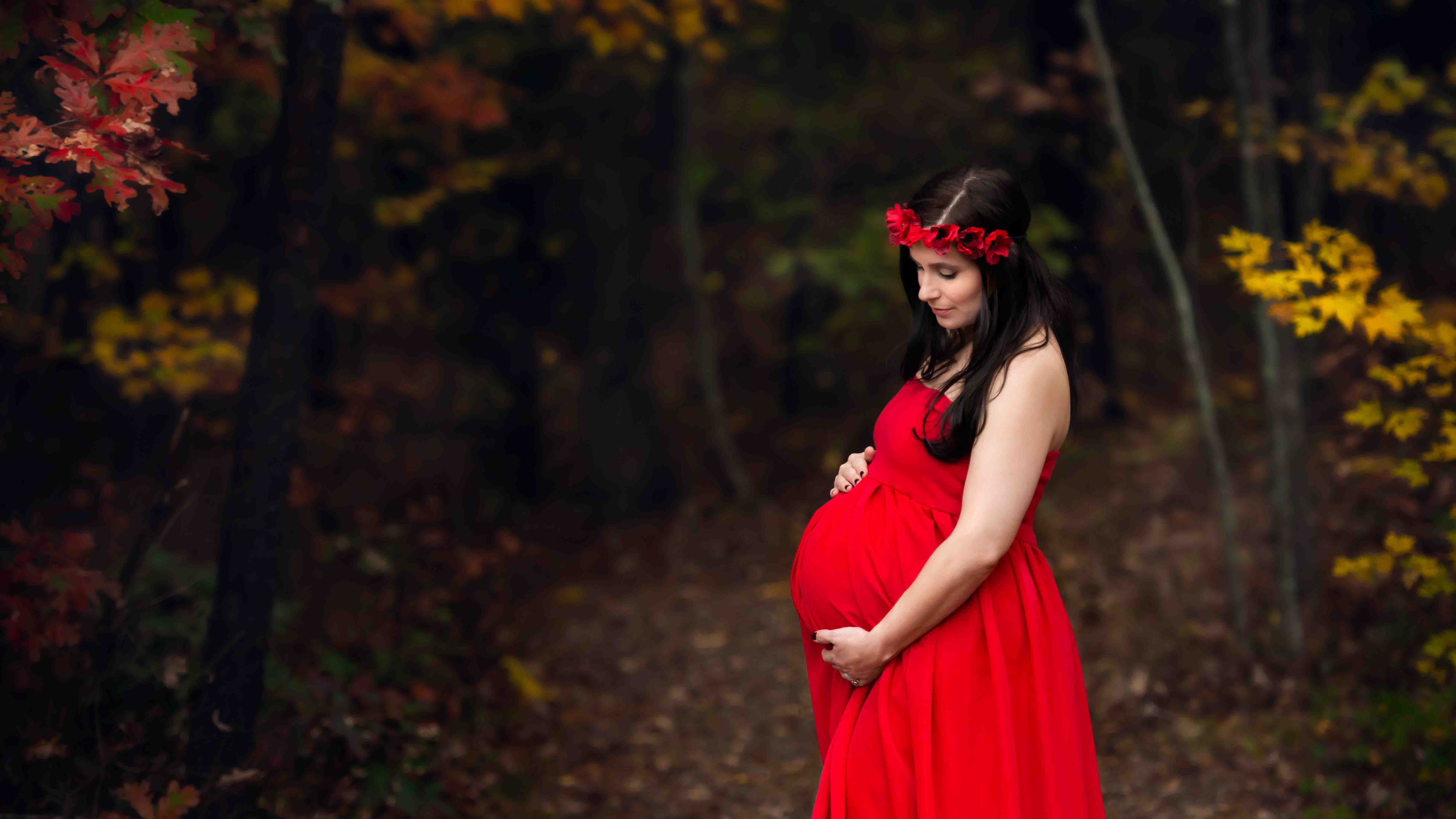 Maternity photo of a-mom-to-be in red gown at teh Asheville Arboretum.