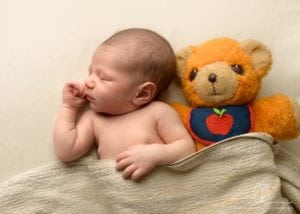 Baby sleeping with his bear next to him.