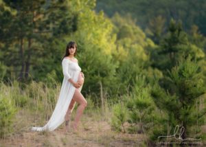 Beautiful expecting mom in long white gown.