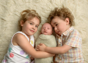 Siblings with their newborn baby brother.