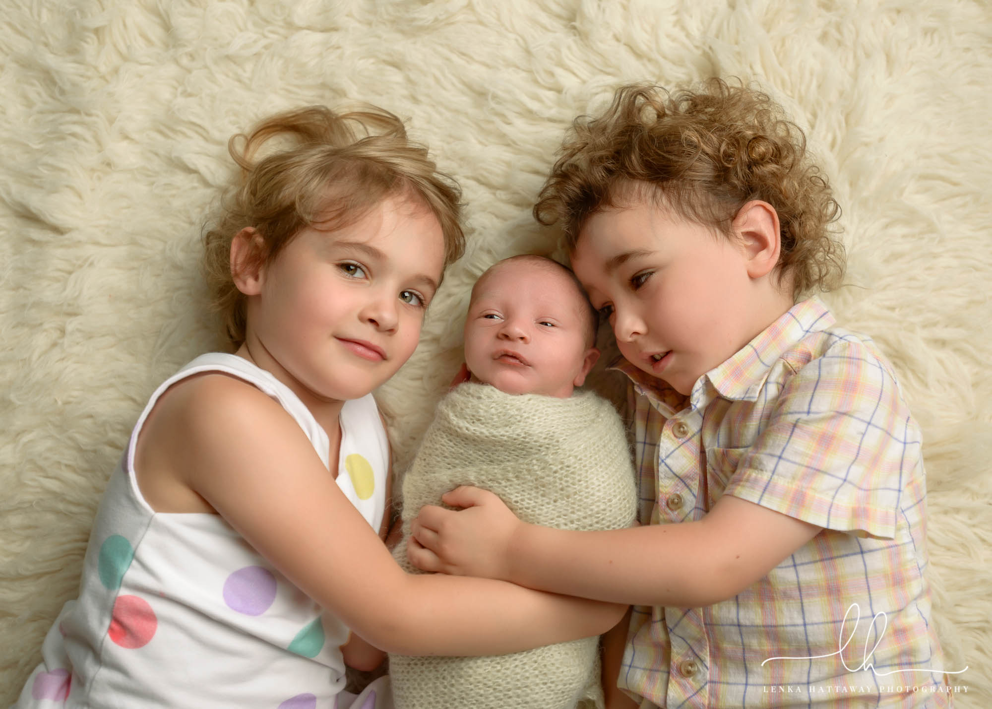 Newborn photo of siblings with their newborn baby brother.