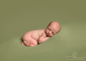 Sweet newborn image on green blanket.
