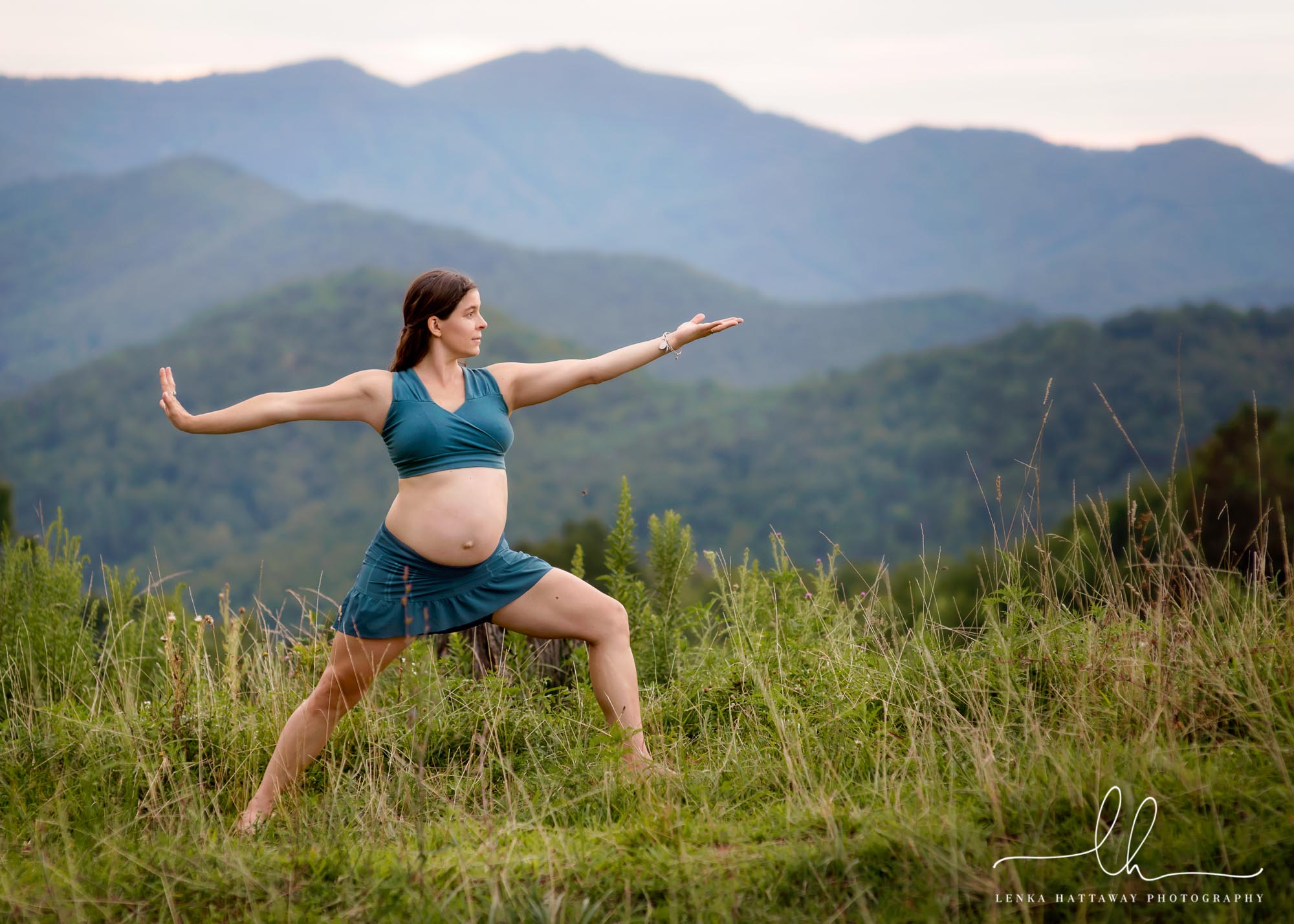 Pregnant mom doing yoga with mountains in the background.