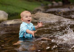 Sweet baby boy splashing in a creek.