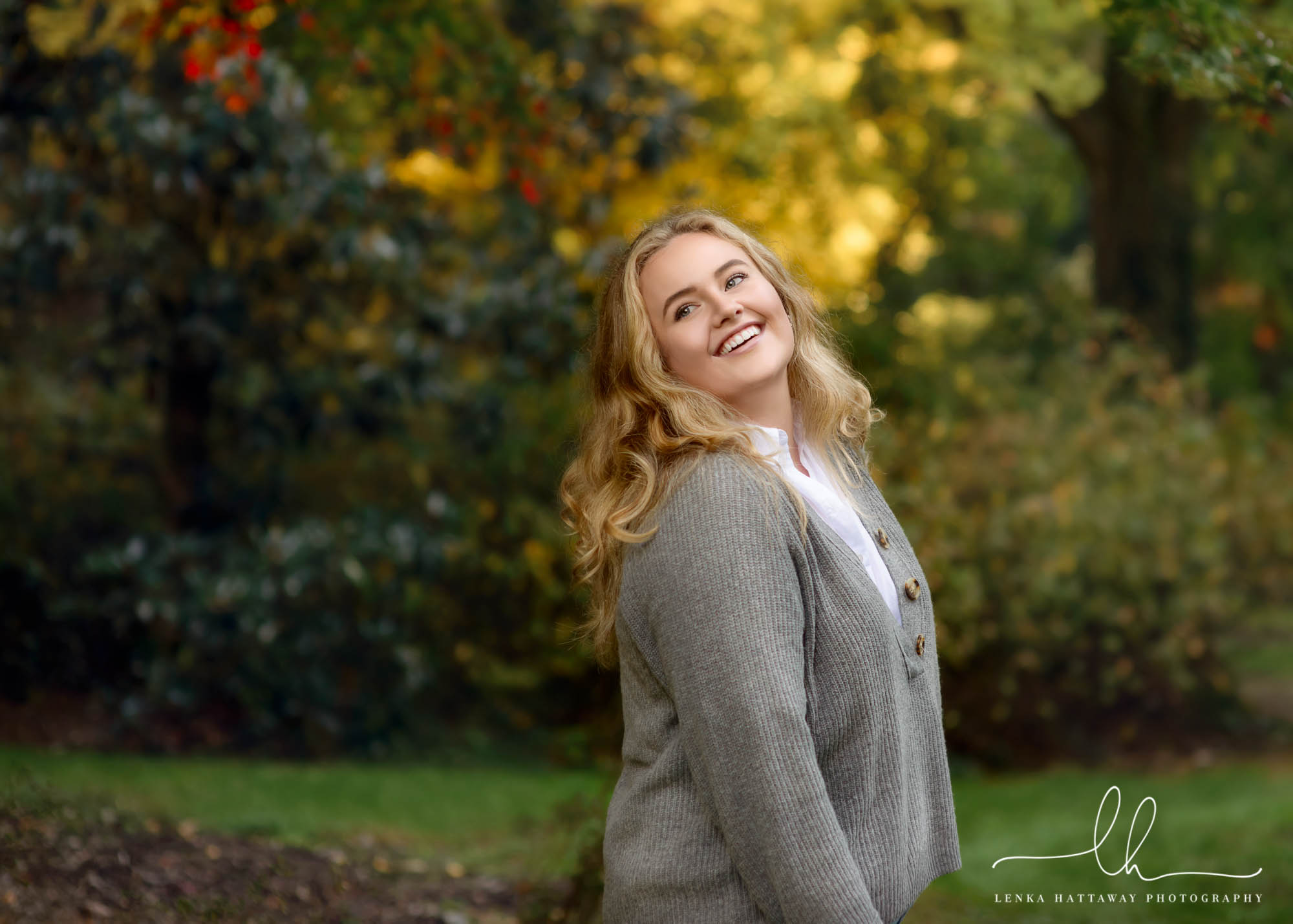 Senior in front of fall foliage suring her photo session.