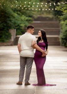 Couple looking at each other during maternity photo sesssion at the Asheville Arboretum.
