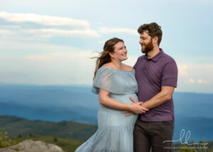 Asheville maternity photography of an expecting couple with mountain background.