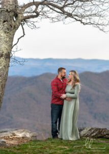 Gorgeous photo of a couple expecting baby with mountain background.