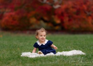 Fall family photo at Biltmore of adorable baby girl with fall foliage in the background.